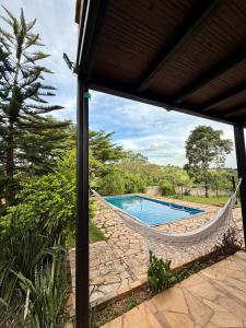 a hammock on a patio with a swimming pool at Recanto do Amaral - Espaço de Lazer e Eventos in Betim +24 photos