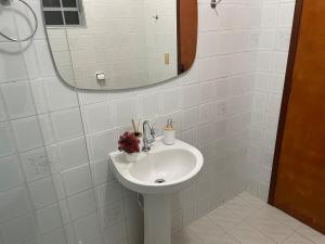a white bathroom with a sink and a mirror at Seu refúgio com três quartos e garagem gigante in Indaiatuba +17 photos