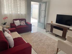 a living room with a couch and a flat screen tv at Seu refúgio com três quartos e garagem gigante in Indaiatuba