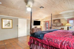 a bedroom with a bed with a red comforter at Guadalupe Getaway in Kerrville