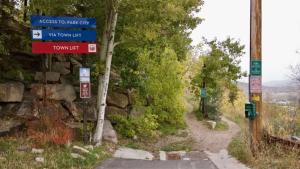 a street sign on a dirt road with trees at Summit Home Multi-level with PC Views Ski Trail in Park City