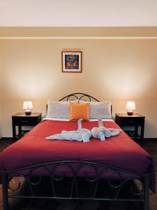 two towels on a bed with two stuffed animals on it at York House in La Paz +38 photos