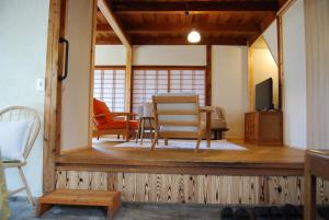 a living room with a table and chairs and a television at 一軒宿 百々 private house rental doudou in Mitoyo