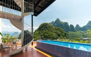 a resort with a pool and mountains in the background at Yangshuo MUSE Mountain View Retreat in Guilin