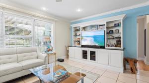 a living room with a white couch and a tv at Lakehouse Sunsets in Sebastian