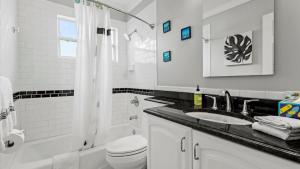 a white bathroom with a sink and a shower at Lakehouse Sunsets in Sebastian +33 photos