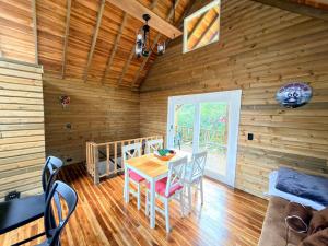 a dining room with a table and chairs in a cabin at WOODEN HOUSE Hermoso alojamiento en Llanogrande Rionegro cerca a Medellín & Aeropuerto JMC in Rionegro