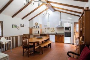 a large kitchen with a wooden table and chairs at Quinta da Raiz in Canedo de Basto