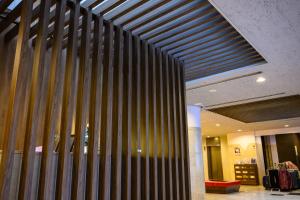 a lobby with a wall of vertical wooden panels at HOTEL MYSTAYS Ueno East in Tokyo