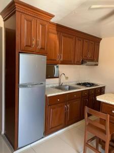 a kitchen with a white refrigerator and wooden cabinets at Suites Posada Obregon in Ciudad Obregón