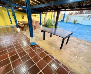 a wooden table on a patio with a table at Casa em Ilha Comprida in Ilha Comprida