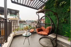 a balcony with chairs and a table on a building at Nesta Home - Old Street in Hanoi