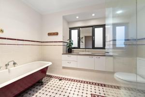 a bathroom with a tub and a sink and a toilet at Gated & Secure Single-Level Home in CBD in Turner +30 photos