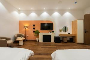 a hotel room with two beds and a flat screen tv at Nesta Home - Old Street in Hanoi