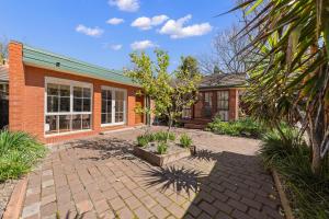 a brick house with a courtyard in front of it at Gated & Secure Single-Level Home in CBD in Turner
