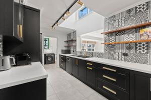 a kitchen with black cabinets and white counter tops at Gated & Secure Single-Level Home in CBD in Turner