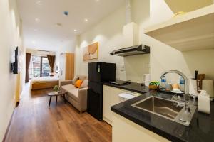 a kitchen and a living room with a couch at Nesta Home - Old Street in Hanoi