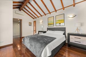 a bedroom with a large bed and a wooden floor at Gated & Secure Single-Level Home in CBD in Turner