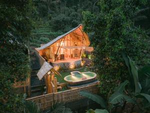 a small wooden house with a tub in the yard at Sunrise Hill Bamboo House-Private Jungle Villa in Sidemen