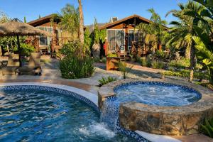 a pool with a waterfall in a yard at Paraíso del Valle in Ensenada