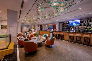 a restaurant with a bar with people sitting at tables at GRAND CITITEL Hanoi Hotel & Spa in Hanoi