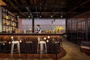 a man standing behind a bar in a restaurant at GRAND CITITEL Hanoi Hotel & Spa in Hanoi