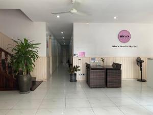 a lobby with a table and plants in a building at Nico’s Hotel and SkyBar in Siem Reap