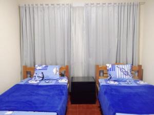 a bedroom with two beds with blue sheets and a window at Finca Turistica Rancho Grande in Santana