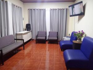 a waiting room with blue chairs and a flat screen tv at Finca Turistica Rancho Grande in Santana