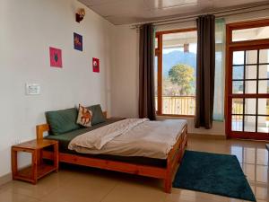 a bedroom with a bed and a large window at Bir Nest Hostel in Bīr