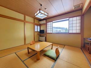 a living room with a table and a window at ドッグランがある宿-ペンション歩野慕野-honobono in Kitashiobara