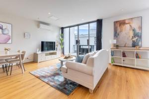 a living room with a white couch and a table at Comfortable Loft Living in Footscray in Melbourne