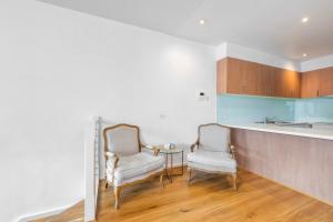 a kitchen with two chairs and a table in it at Comfortable Loft Living in Footscray in Melbourne +11 photos