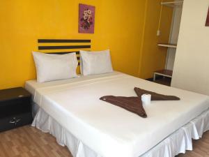 a large white bed with two towels on it at Coco's Guest House in Phi Phi Islands