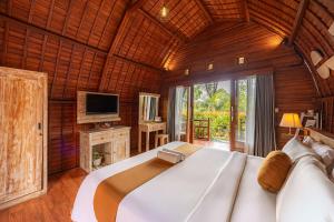 a bedroom with a large bed in a wooden room at Cove Jiwana Villa in Nusa Dua