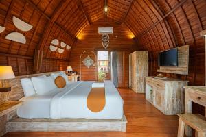 a bedroom with a large bed in a wooden room at Cove Jiwana Villa in Nusa Dua