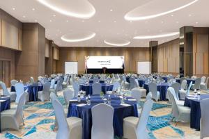 a conference room with tables and chairs and a projection screen at Golden Tulip Springhill Lampung in Bandar Lampung +76 photos