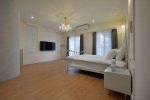 a bedroom with a bed and a television in it at Station B&B in Tainan