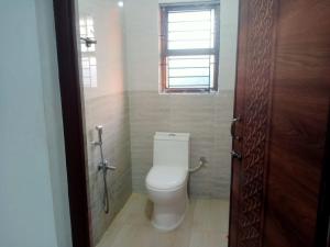a bathroom with a toilet and a window at The Palindrome in Guwahati