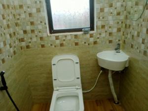 a bathroom with a toilet and a sink at The Palindrome in Guwahati