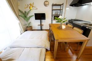 a dining room with a table and a table and a kitchen at カラハーイもとぶ 2-3 in Motobu