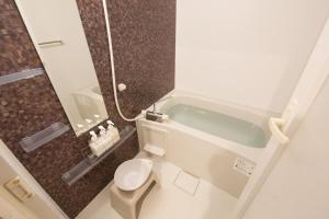 a small bathroom with a toilet and a shower at カラハーイもとぶ 2-3 in Motobu