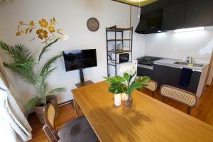 a dining room with a table and a kitchen at カラハーイもとぶ 2-3 in Motobu