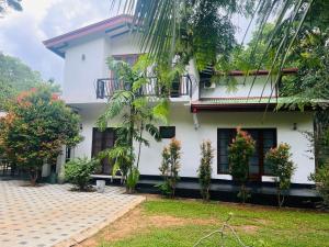 a white house with plants in front of it at Mashi's Villa in Sigiriya