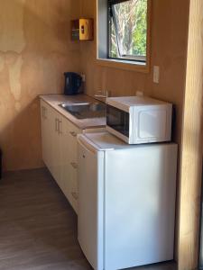 a small kitchen with a microwave on top of a refrigerator at Rural Getaway in Thames