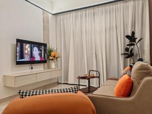 a living room with a couch and a flat screen tv at White House in Malacca
