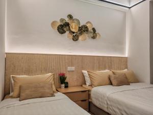 a bedroom with two beds and a clock on the wall at White House in Malacca +29 photos