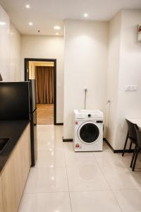 a kitchen with a washing machine sitting on the floor at Annaz Suite Crown Pacific in Bintulu +3 photos