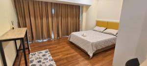 a bedroom with a bed and a large window at Annaz Suite Crown Pacific in Bintulu