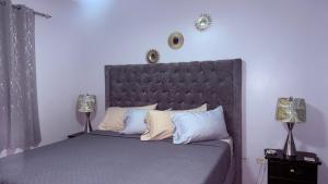 a bedroom with a large gray bed with two lamps at Jamrock Suites in Kingston